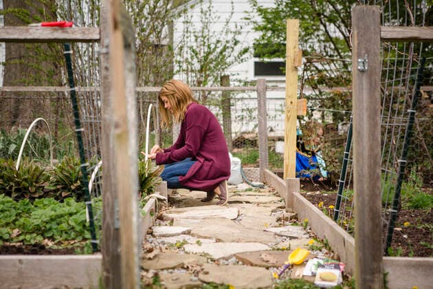 IMAGO Creative, Frühling, Start der Garten-Saison IMAGO Creative: Landleben, Mit Nachhaltigkeit grün auf dem Land leben A woman plants seeds in her garden while child plays in background Columbus, OH, United States CR_RETI200615B-381144-01 ,model released, Symbolfoto