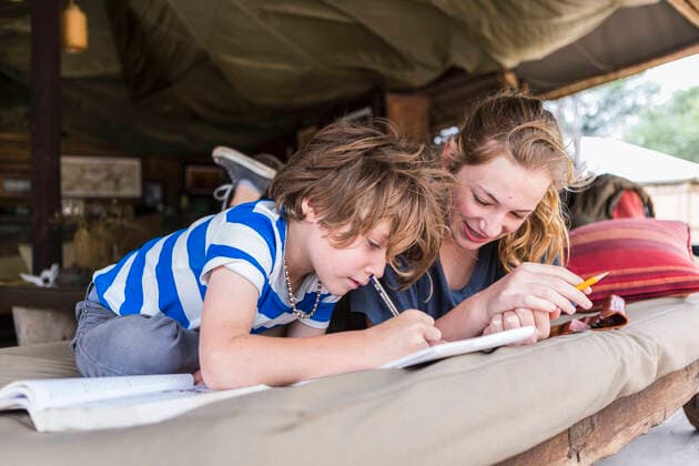 IMAGO Creative: Klimawandel - Umwelterziehung Brother and sister doing homework together in a tented camp in Botswana Botswana,Brother and sister doing homework together in a tented camp in Botswana  Brother and sister doing homework together in a tented camp in Botswana