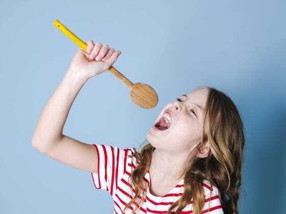  Creative Highlights Symbolfotos pretty cool and young girl uses cooking spoon as microphone and sings in front of blue background and is having a lot of fun Copyright: xphotographie_Hannes_Eichingerx Panthermedia26942731 ,model released, Symbolfoto