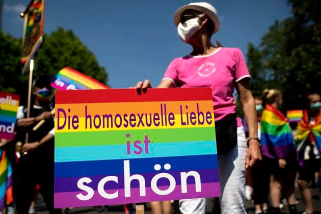 Christopher Street Day Berlin DEU, Deutschland, Germany, Berlin, 27.06.2020 Teilnehmer mit Schild Die Homosexuelle Liebe ist Schoen in den Regenbogenfarben auf der schwul-lesbischen Gedenkparade Christopher Street Day CSD Parade unter dem Motto Berlin Pride Save our Community Save Our Pride in Berlin. Der Marsch fand aufgrund der Corona-Pandemie in reduzierter Form statt und stand auch unter dem Einfluss der Black Lives Matter Bewegung. Participants with sign Die Homosexuelle Liebe ist Schoen in rainbow colours at the Berlin s annual Christopher Street Day CSD Pride parade in Berlin. Gays and lesbians all around the world are celebrating the Christopher Street Day gay and lesbian pride parade despite the coronavirus pandemic under the slog