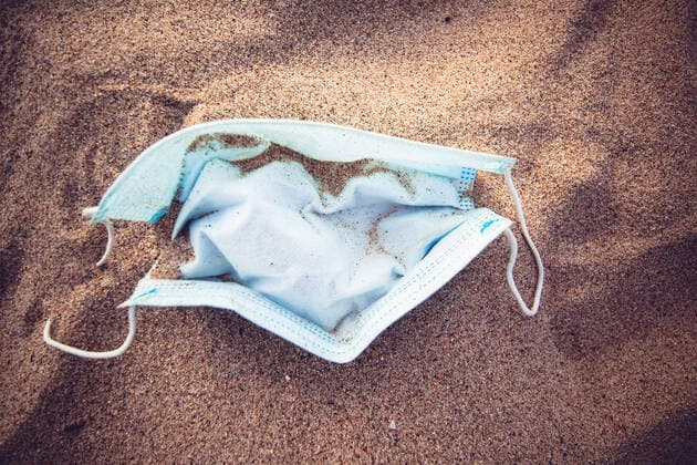 Corona crisis in the USA Carelessly thrown away respirator on the sandy beach of Hermosa, Los Angeles