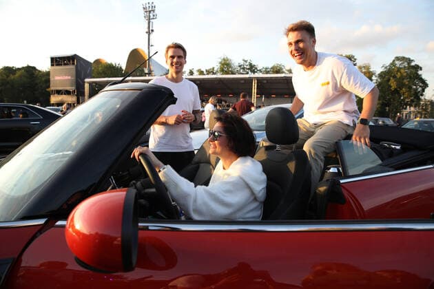 MOSCOW, RUSSIA - JULY 4, 2020: Members of the audience in a convertible car during a drive-in concert by The Hatters gypsy folk rock band in Luzhniki. The concert, in which the sound is broadcast to the cars via FM radio, is part of LIVE&DRIVE, a series of live drive-in concerts organised by the TCI concert agency and SAV Entertainment Group during the pandemic of the novel coronavirus disease (COVID-19). Vyacheslav Prokofyev TASS  TS0DF269