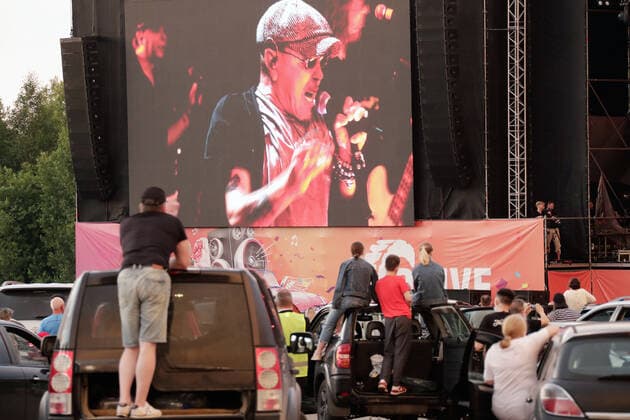 MOSCOW REGION, RUSSIA - JULY 4, 2020: The video screen shows singer song writer Garik Sukachov as he performs in a drive-in concert in Yakhroma Park in the town of Dmitrov, Moscow Region. The concert, in which the sound is broadcast to the cars via FM radio, is part of LIVE&DRIVE, a series of live drive-in concerts organised by the TCI concert agency and SAV Entertainment Group during the pandemic of the novel coronavirus disease (COVID-19). Mikhail Metzel TASS  TS0DF243