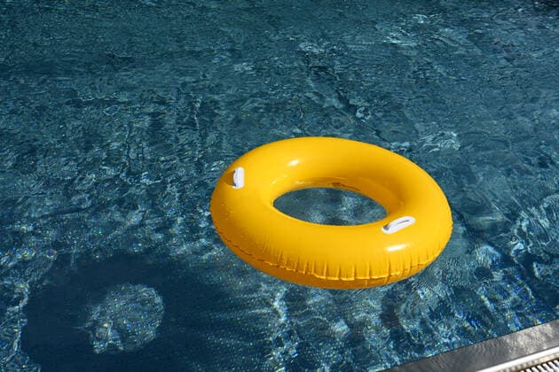 Symbolbild Freibad- ein gelber Schwimmreifen schwimmt auf der Wasseroberfläche eines Schwimmbeckens, Löffingen, Baden-Württemberg, Deutschland *** Symbolic image of an open-air swimming pool a yellow swimming tire floating on the surface of a swimming pool, Löffingen, Baden Württemberg, Germany