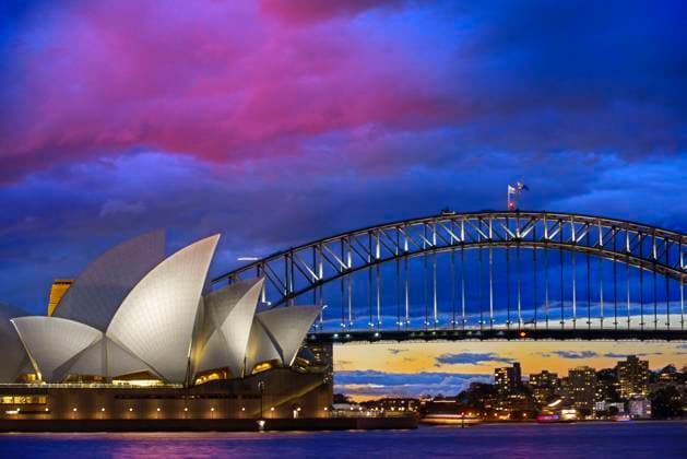 World famous Sydney Opera House and Harbour bridge at sunset. Blurred clouds and lights of landmarks reflect in blurred waters of Harbour. Sydney, New South Wales, Australia Sydney New South Wales Australia Copyright: xSergixReboredox SRE-001-EJ2894