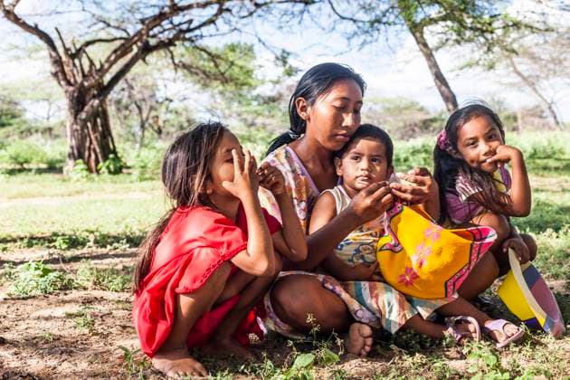 IMAGO Cultures of the world, Wayuu Volk in Kolumbien Young Wayuu woman and her children sitting outside while she knits in a rancheria , or traditional Wayuu settlement in La Guajira, Colombia. Knitting, crocheting and weaving are fundamental to the social and economic lives of Wayuu women in La Guajira, Colombia. Uribia Colombia Copyright: xJasonxRothex JRO_COL-2234