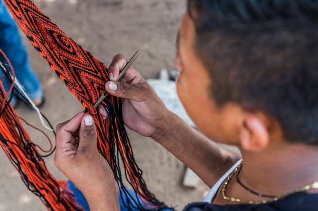 IMAGO Cultures of the world, Wayuu Volk in Kolumbien Wayuu indigenous boy in La Guajira, Colombia knitting a sash or strap. Weaving is mostly a female profession in Wayuu communities, but some men also weave hats and textiles. Colombia Copyright: xJasonxRothex JRO_COL-9141