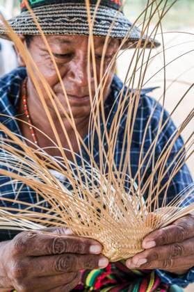 IMAGO Cultures of the world, Wayuu Volk in Kolumbien Wayuu indigenous man constructing a bamboo hat in the regional style of La Guajira, Colombia. Weaving is mostly a female profession in Wayuu communities, but some men also weave hats and textiles. Uribia Colombia Copyright: xJasonxRothex JRO_COL-9386