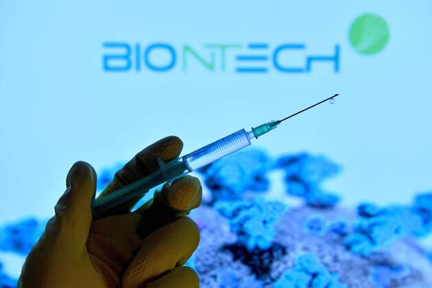Theme picture,symbol photo Corona vaccine A hand wrapped in rubber gloves holds a disposable syringe with vaccine for injection with a cannula BIONTECH Biotechnology Company