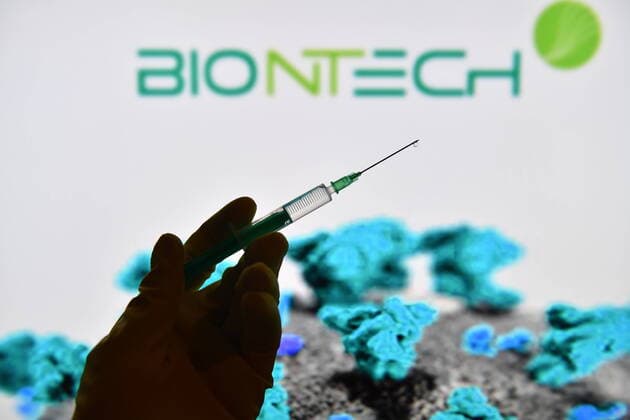 Theme picture,symbol photo Corona vaccine A hand wrapped in rubber gloves holds a disposable syringe with vaccine for injection with a cannula BIONTECH Biotechnology Company