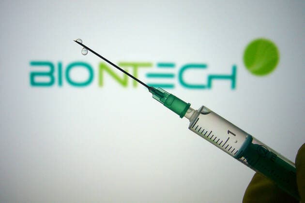 Theme picture,symbol photo Corona vaccine A hand wrapped in rubber gloves holds a disposable syringe with vaccine for injection with a cannula BIONTECH Biotechnology Company