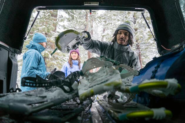 Young African-American male lifts his snowy skis out of the trunk while his friends talk United States, California, South Lake Tahoe CR_FGUQ200708J-301206-01 ,model released, Symbolfoto