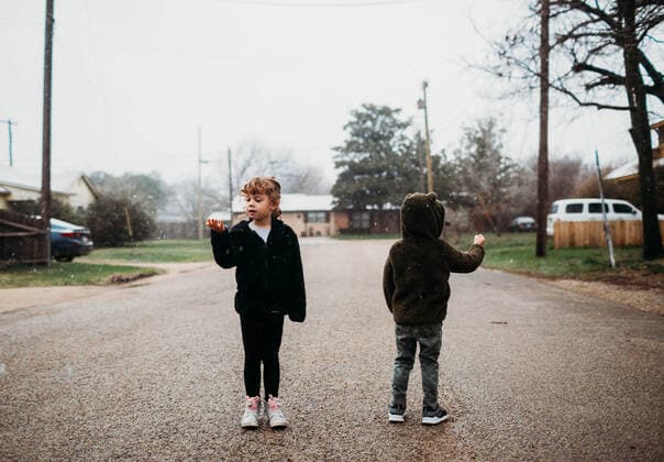 Young brother and sister standing in street catching snow flakes Fort Worth, TX, United States CR_TAHI200701-413937-01 ,model released, Symbolfoto