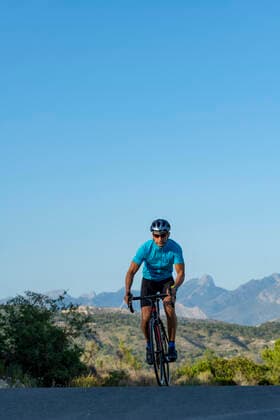 A man, standing up on his pedals, bikes uphill in Costa Blanca Relleu, Valencian Community, Spain CR_TNKS200628A-425513-01 ,model released, Symbolfoto