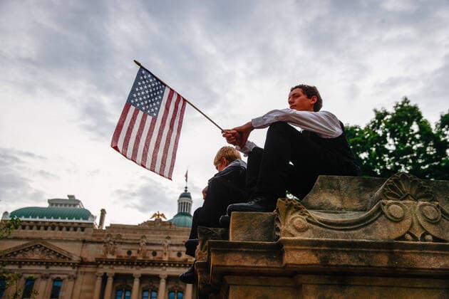 July 19, 2020, Indianapolis, Indiana, United States: A protester holds an American flag while listening to speakers during the We Will Not Comply anti mask rally..People protest against both the Indianapolis mayor Joe Hogsett™s mask order and Indiana governor Eric Holcomb s extension of the state shutdown..The U.S. Department of Health recorded a total of 3,898,550 infections, 143,289 death and 1,802,338 recovered since the beginning of the Coronavirus (Covid-19) outbreak. Indianapolis United States - ZUMAs197 20200719_zaa_s197_096 Copyright: xJeremyxHoganx