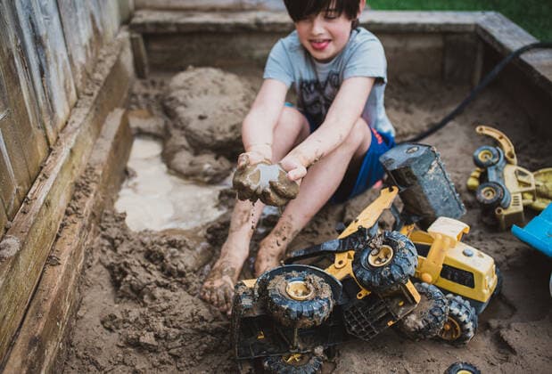 IMAGO Creative: Sommer, Sommertage im Garten Young boy playing in muddy sandbox filled with toy trucks and shovels. Kingston, ON, Canada CR_DOHO200717F-443723-01 ,model released, Symbolfoto