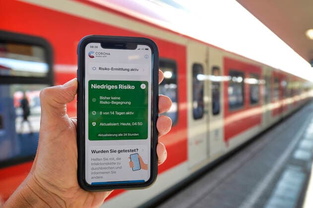 Hand holding smartphone with Corona Warn APP on the platform, Corona crisis, Stuttgart, Baden Württemberg, Germany Coronavirus
