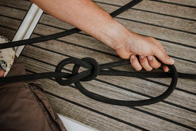 Hands of sailor tying marine knot in sailboat model released Symbolfoto property released GMLF00309
