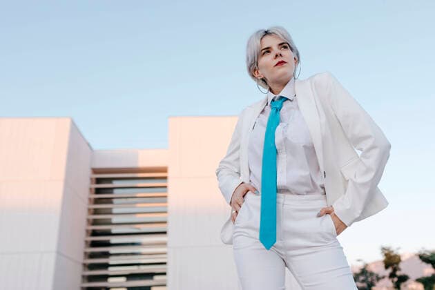 Young woman wearing white suit posing while standing against clear sky in city model released Symbolfoto TCEF00894