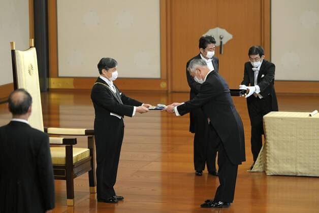 Imperial conferment of decorations Japanese Emperor Naruhito (2nd from L) confers the Grand Cordon of the Order of the Sacred Treasure to former chief of the Self-Defense Forces Joint Staff Ryoichi Oriki at the Imperial Palace in Tokyo on July 31, 2020. Attendees wear face masks amid the novel coronavirus pandemic. (Pool photo) 
