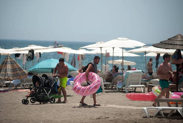 August 1, 2020, Malaga, Spain: A man carrying a pink float as he leaves Rincon Sol beach of Torremolinos during a hot summer day..The first heavy heat wave hits the country with high temperatures. In Andalusia, according to the Spanish Meteorology Agency, majority of the cities are in orange warning with temperatures over 40 degrees Celsius during the weekend. Malaga Spain - ZUMAs197 20200801_zab_s197_017 Copyright: xJesusxMeridax