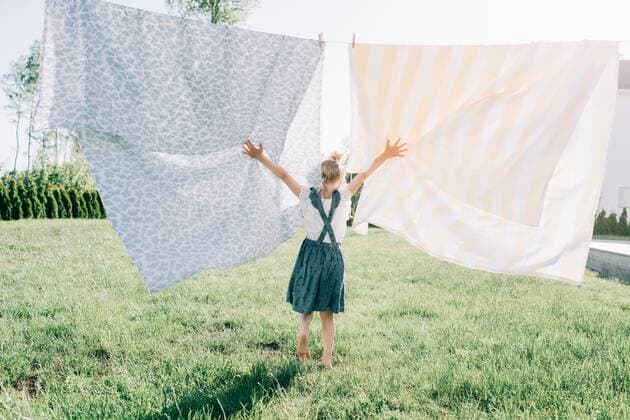 IMAGO Creative: Sommer, Sommertage im Garten young girl dancing through the washing on the line in the yard Norrtälje, Stockholm County, Sweden CR_RABE200715-422342-01 ,model released, Symbolfoto