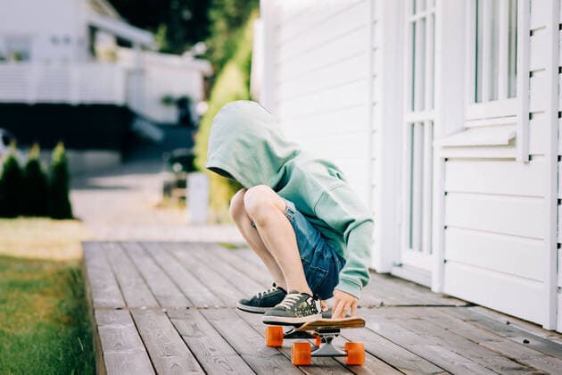 boy sat on a skateboard with his hood up hiding his face Norrtälje, Stockholm County, Sweden CR_RABE200724A-456870-01 ,model released, Symbolfoto