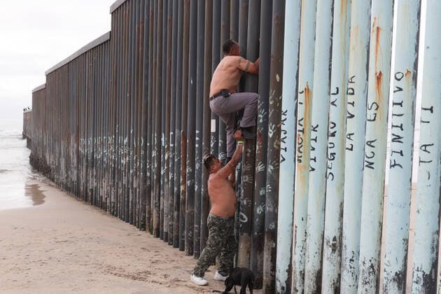 News Bilder des Tages Migrants climb the wall that divides Mexico from US Migrant walking at the beach of Tijuana in an area that is restricted by the COVID-19 contingency. Tijuana Chihuahua Mexico Copyright: DavidxPeinado