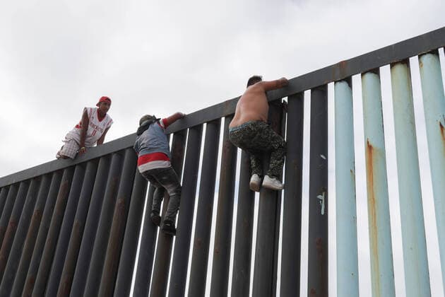Migrants climb the wall that divides Mexico from US Migrant walking at the beach of Tijuana in an area that is restricted by the COVID-19 contingency. Tijuana Chihuahua Mexico Copyright: DavidxPeinado