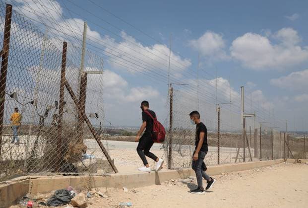 August 5, 2020: West Bank, Palestine. 05 August 2020. Palestinians cut through a gap in the Israeli security fence near the West Bank village of FarÃ¢â‚¬â ¢un, in the Tulkarem Governorate. The Israeli separation wall has been justified by Israel as a security barrier, yet it has not been built just along the Green Line separating the West Bank from Israel as it cuts through the West Bank for 85% of its route. This means that Israel through the barrier has annexed more than 9% of the West Bank, has divided numerous Palestinian villages and separated communities, and isolated 25,000 Palestinians. The barrier is deemed a violation of international law, as well as a ploy used by Israel to further annex Palestinian land - ZUMAd99_ 20200805_zap_d99_020 Copyright: xMohammedxTurabix