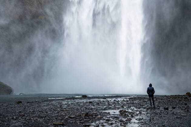 IMAGO Creative: Weltuntergang A meditative man standing in the water fog of Skoga waterfall in Iceland looking up at nature  572368421630902341