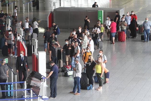 After the removal of most travel warnings during the corona crisis, air traffic is slowly picking up speed again Waiting passengers with baggage stand with mouth nose cover Queuing at check-in counters n in Terminal 1 in departure hall B at Frankfurt Airport, Hesse, Germany