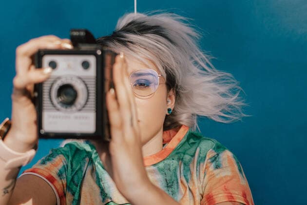 A young woman taking pictures with an analog camera in a colorful dress Asturianos, CL, Spain CR_ADRO200803-461992-01 ,model released, Symbolfoto ,property released