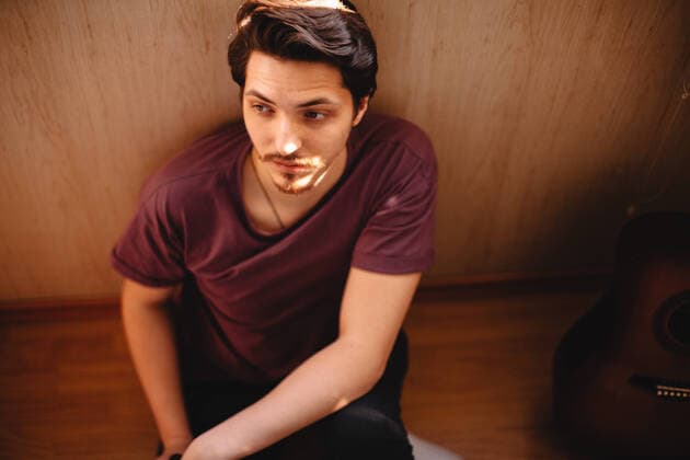 IMAGO Creative: Gesellschaft, Armut Thoughtful young man sitting on balcony floor at home CR_DMBE200812-379078-01 ,model released, Symbolfoto