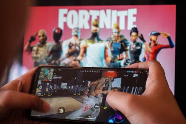 Bilder des Jahres 2020, News 08 August News Themen der Woche KW33 News Bilder des Tages August 15, 2020, Makassar, South Sulawesi, Indonesia: A child is playing a game on a cellphone with a picture of the Fortnite game on the computer screen in the background. Apple and Google announced their decision to remove Fortnite games from the App Store and Google Play app stores. Makassar Indonesia - ZUMAb223 20200815_zip_b223_003 Copyright: xHerwinxBaharx