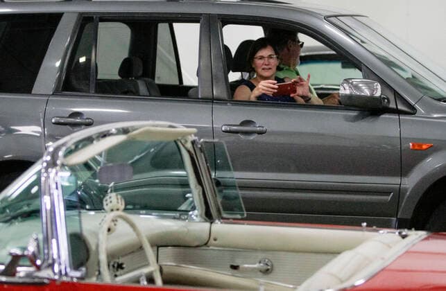 (200816) -- ABBOTSFORD (CANADA), Aug. 16, 2020 -- A woman takes photo of vintage cars from her car during the Wings and Wheels drive-thru event in Abbotsford, British Columbia, Canada, Aug. 16, 2020. The Wings and Wheels drive-thru event featuring about 11,100 square meters of vintage buses, tractors, antique cars as well as vintage airplanes was held in Abbotsford of Canada from Aug. 15 to 16. (Photo by Xinhua) CANADA-ABBOTSFORD-WINGS AND WHEELS DRIVE-THRU EVENT LiangxSen 
