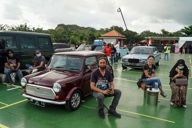 August 17, 2020, Gianyar, Bali, Indonesia: Spectators sits next to their car. First drive-in music concert in Bali held in Ubud region amid Covid-19 coronavirus outbreak to encourage Bali musicians to keep productive and having health mentality after 5 months pandemic period. The spectators sllowed to be outside the car which still inside each boundary line. Gianyar Indonesia - ZUMAb245 20200817_zip_b245_035 Copyright: xDickyxBisinglasix
