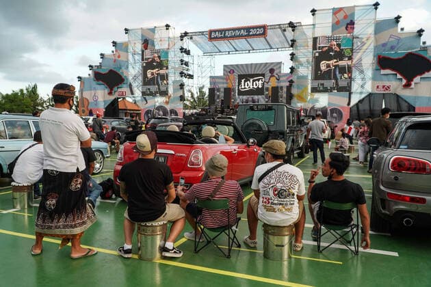 August 17, 2020, Gianyar, Bali, Indonesia: Spectators sits next to their car. First drive-in music concert in Bali held in Ubud region amid Covid-19 coronavirus outbreak to encourage Bali musicians to keep productive and having health mentality after 5 months pandemic period. The spectators sllowed to be outside the car which still inside each boundary line. Gianyar Indonesia - ZUMAb245 20200817_zip_b245_040 Copyright: xDickyxBisinglasix