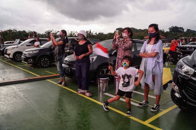 August 17, 2020, Gianyar, Bali, Indonesia: Spectators stands in front of their car. First drive-in music concert in Bali held in Ubud region amid Covid-19 coronavirus outbreak to encourage Bali musicians to keep productive and having health mentality after 5 months pandemic period. The spectators sllowed to be outside the car which still inside each boundary line. Gianyar Indonesia - ZUMAb245 20200817_zip_b245_044 Copyright: xDickyxBisinglasix