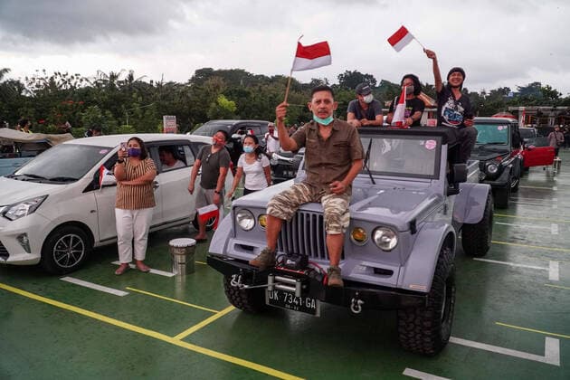 August 17, 2020, Gianyar, Bali, Indonesia: Spectators sits on their car while watching the concert. First drive-in music concert in Bali held in Ubud region amid Covid-19 coronavirus outbreak to encourage Bali musicians to keep productive and having health mentality after 5 months pandemic period. The spectators sllowed to be outside the car which still inside each boundary line. Gianyar Indonesia - ZUMAb245 20200817_zip_b245_045 Copyright: xDickyxBisinglasix