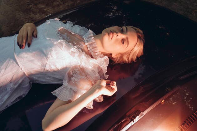 Creative Highlights Symbolfotos a woman in a dress lying on the hood of a car in the evening Brest, Brest Region, Belarus CR_ALLI200811B-463989-01 ,model released, Symbolfoto
