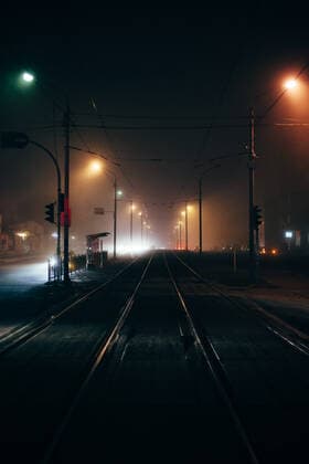 Foggy empty city street with tram ways during autumn at night CR_DMBE200811-413787-01