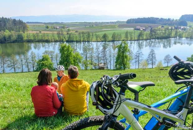 Cycling tour at Lake Constance A cycling tour with the children in spring at Lake Constance between Lindau and Kressbronn Young family enjoys the excursion during the fruit tree blossom on a sunny day in April beautiful place for a break while cycling Lindau Lake Constance Region Bavaria Germany
