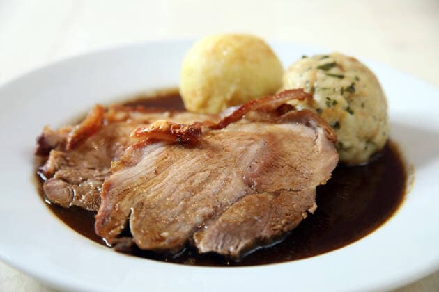 12.08.2020, Berlin - Deutschland. Schweinekrustenbraten mit Kartoffelknödel und Semmelknödel, dazu Krautsalat. Gesehen im Restaurant Engelbecken. *** 12 08 2020, Berlin Germany Roast pork crust with potato dumplings and bread dumplings, served with coleslaw Seen in the restaurant Engelbecken