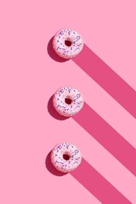 IMAGO Creative, Lifestyle, Barbiecore Studio shot of three sweet doughnuts with sugar sprinkles GEMF04016