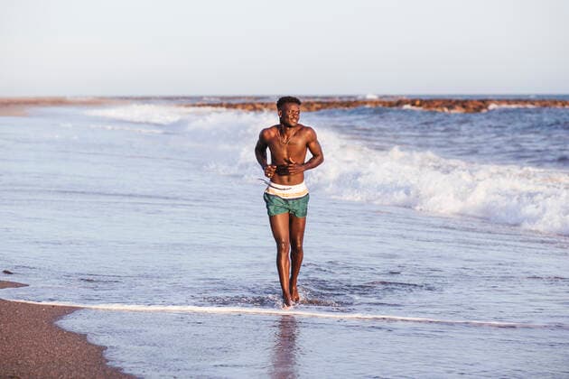 Shirtless African young man running at shore against clear sky model released Symbolfoto property released LJF01707