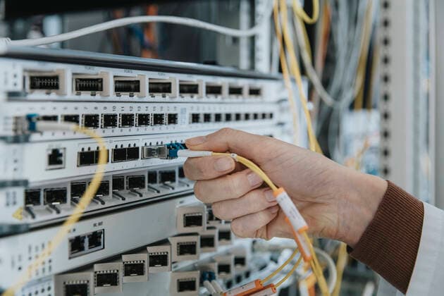Close-up of woman plugging fiber optic cable in equipment at data center model released Symbolfoto property released MFF05956