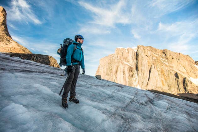 Backpacker standing on glacier below mountain summit. Pangnirtung, NU, Canada CR_JDIP200824B-321219-01 ,model released, Symbolfoto