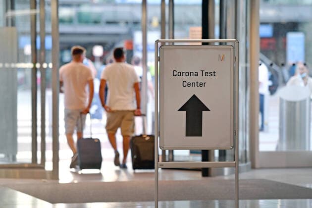 Free corona tests at German airports, such as here at Franz Josef Strauss Airport in Munich on 24 08 2020 Travellers with mouthguards, masks and luggage pass a sign for the corona test after arrival Arriving p