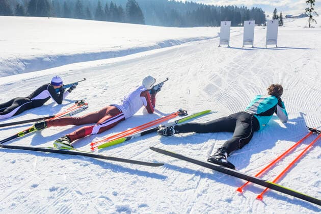 Wintersportler beim Biathlon Freizeit-Biathleten beim Schießen mit einem Lasergewehr an einem kalten und sonnigen Wintertag Drei Biathleten beim Schießen Sulzberg Nordic Zentrum Vorarlberg Österreich *** Winter sportsmen at the biathlon Leisure biathletes shooting with a laser rifle on a cold and sunny winter day Three biathletes shooting Sulzberg Nordic Center Vorarlberg Austria